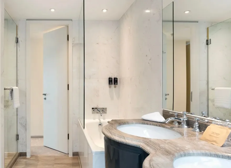 A bathtub by double vanity, Dorsett Suite bathroom, London.