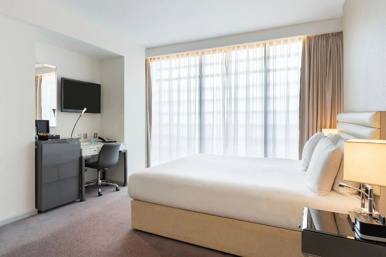 Twin bed, TV, and work desk in Dorsett Shepherds Bush Executive Room.