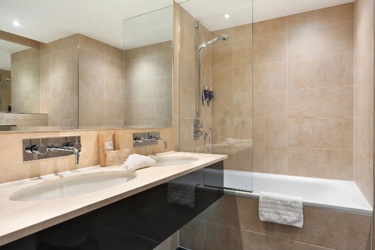 A bathtub next to a double vanity in the Executive Room ensuite bathroom