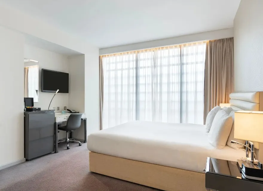 Twin bed, TV, and work desk in Dorsett Shepherds Bush Executive Room.