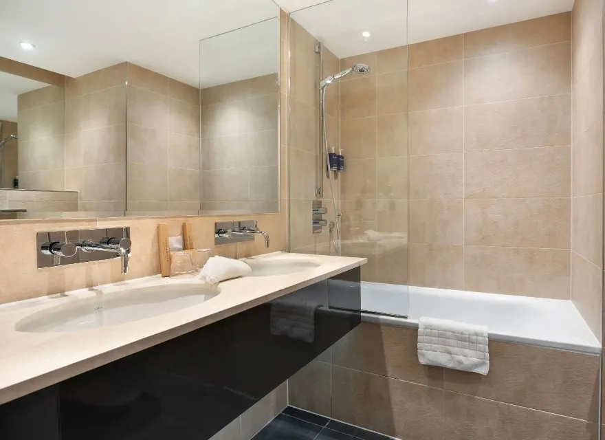 A bathtub next to a double vanity in the Executive Room ensuite bathroom