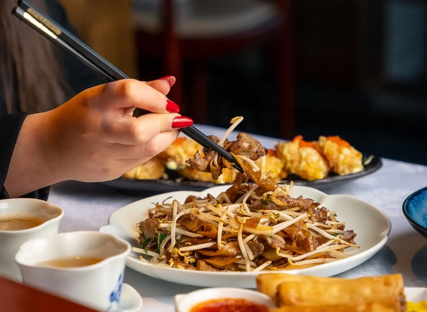 Chopsticks holding Beef Chow Fun at Shikumen, London.