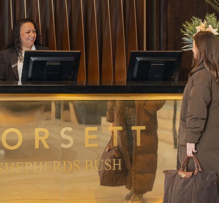 A guest speaking to front desk staff at Dorsett Shepherds Bush London.