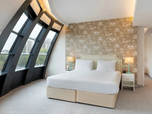 King-size bed with bedside tables in Dorsett Suite, London.