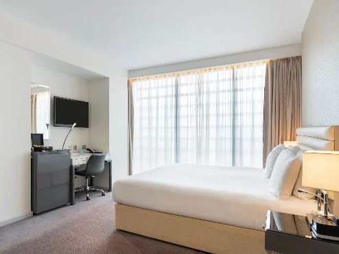 Twin bed, TV, and work desk in Dorsett Shepherds Bush Executive Room.