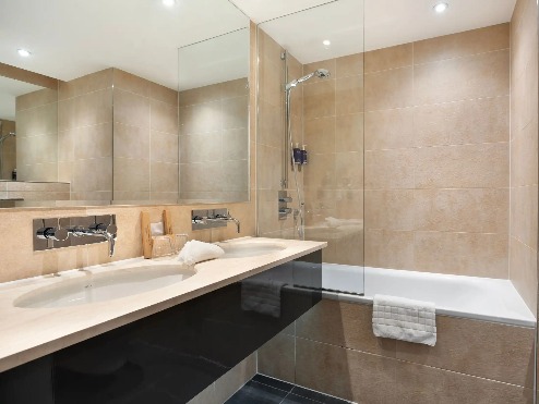 A bathtub next to a double vanity in the Executive Room ensuite bathroom