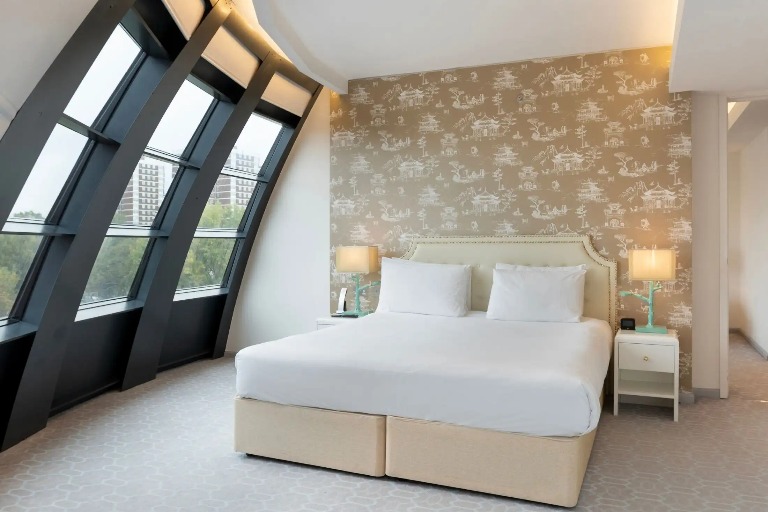 King-size bed with bedside tables in Dorsett Suite, London.