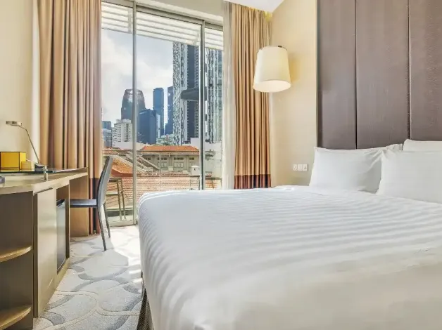 King bed by the window in a Dorsett Singapore Bedroom.