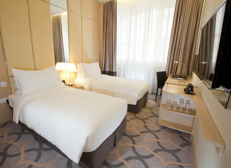 King bed, working desk and TV in the Deluxe Room at Dorsett Singapore.