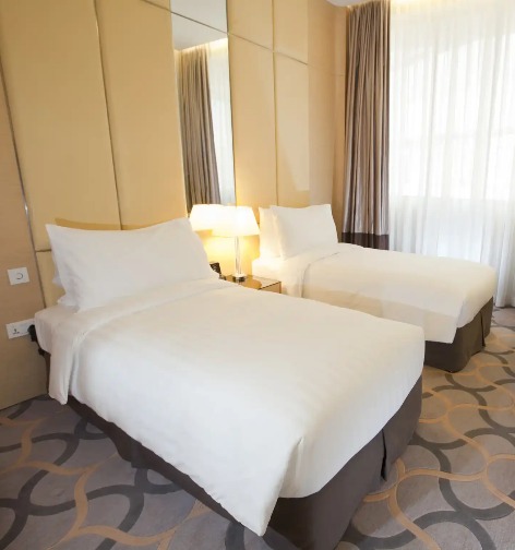 King bed, working desk and TV in the Deluxe Room at Dorsett Singapore.