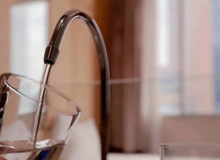 Water being poured into a glass from a tap.