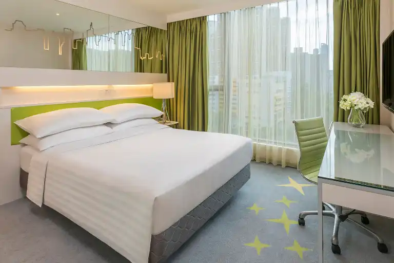 King bed and work desk by the window in Dorsett Tsuen Wan Hotel Room.