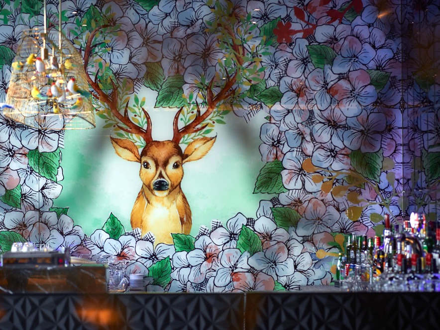 Interior of the 3T Bar at Dorsett Wanchai with a floral mural of deer