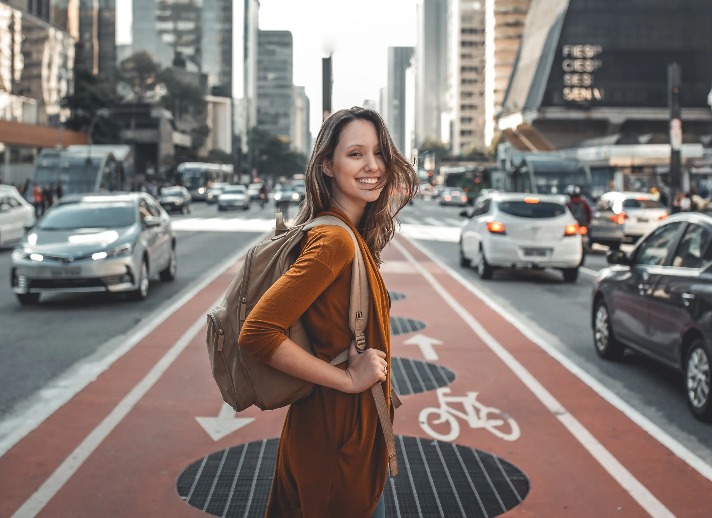 A lady standing by a busy road