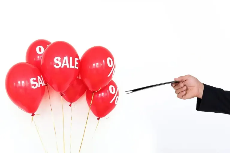 A waiter pointing at red balloons.