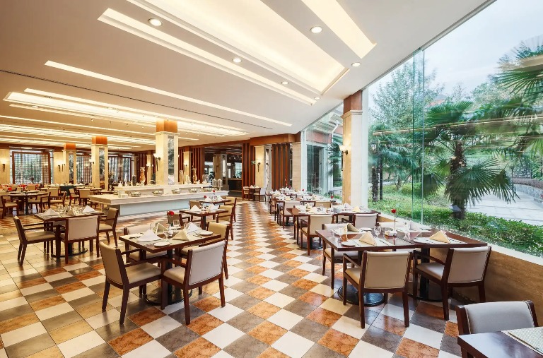 Dining seating by the window with a waterfront view in Lushan Resort.